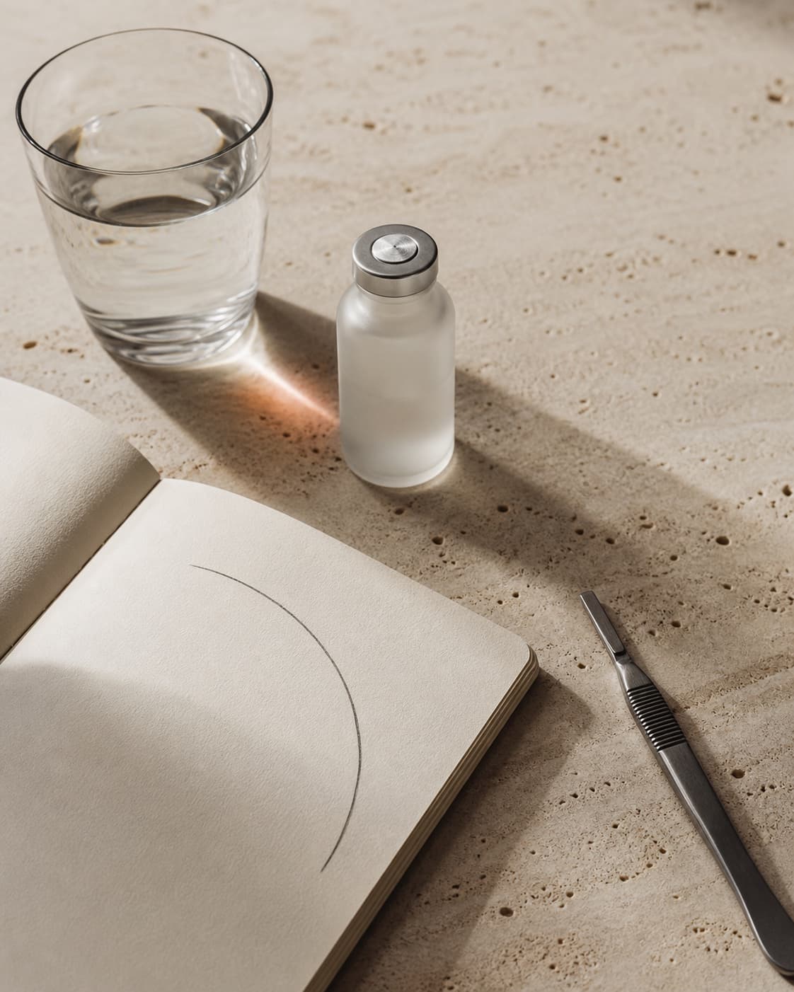 A notebook, glass vial, and care instruments arranged for a private consultation